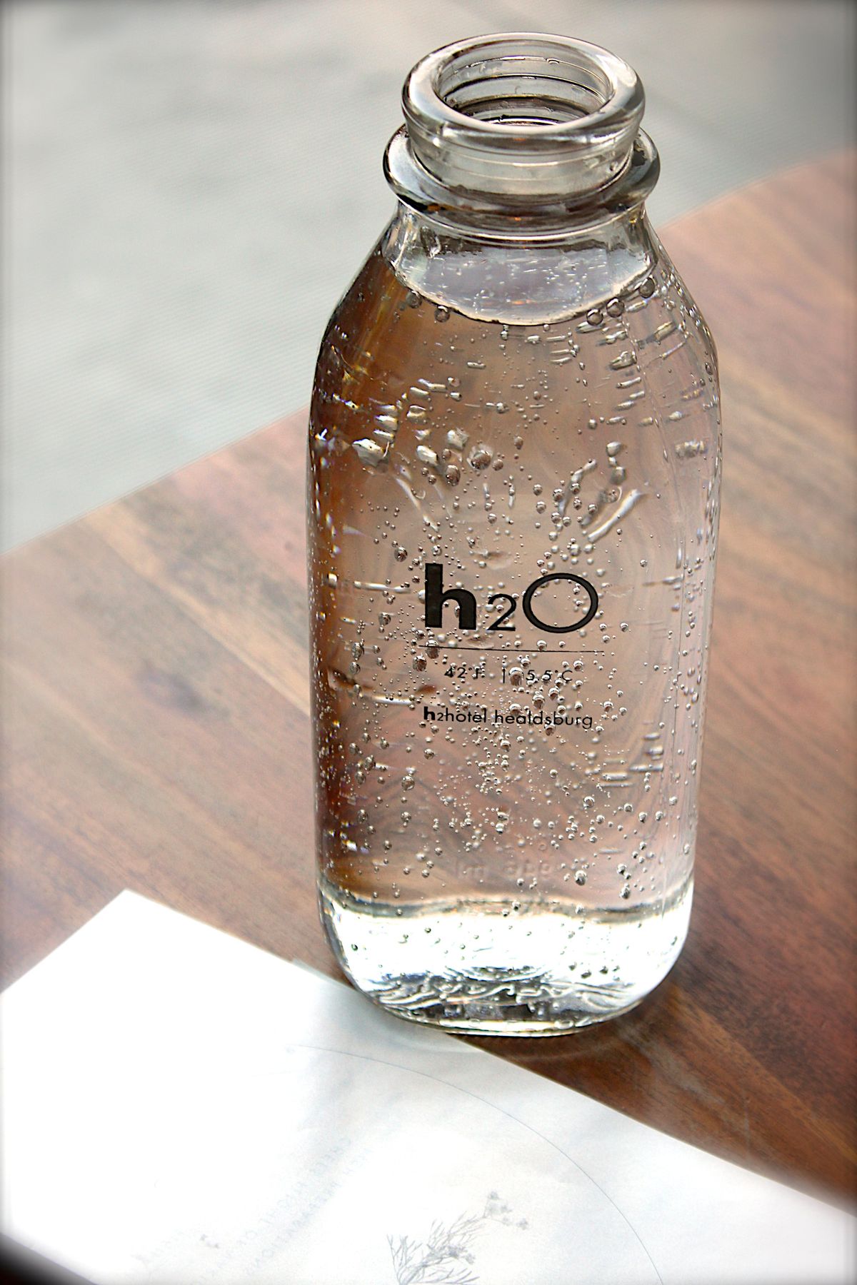 Clear glass bottle filled with pure water on a table