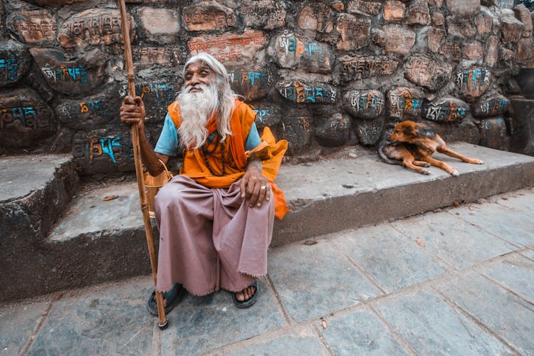 Elderly Man With A Long Gray Beard And A Stick