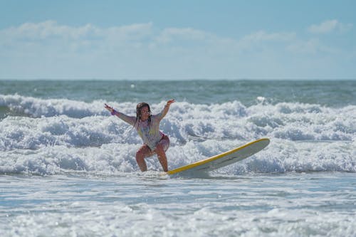 Woman in Long Sleeve Shirt Surfboarding