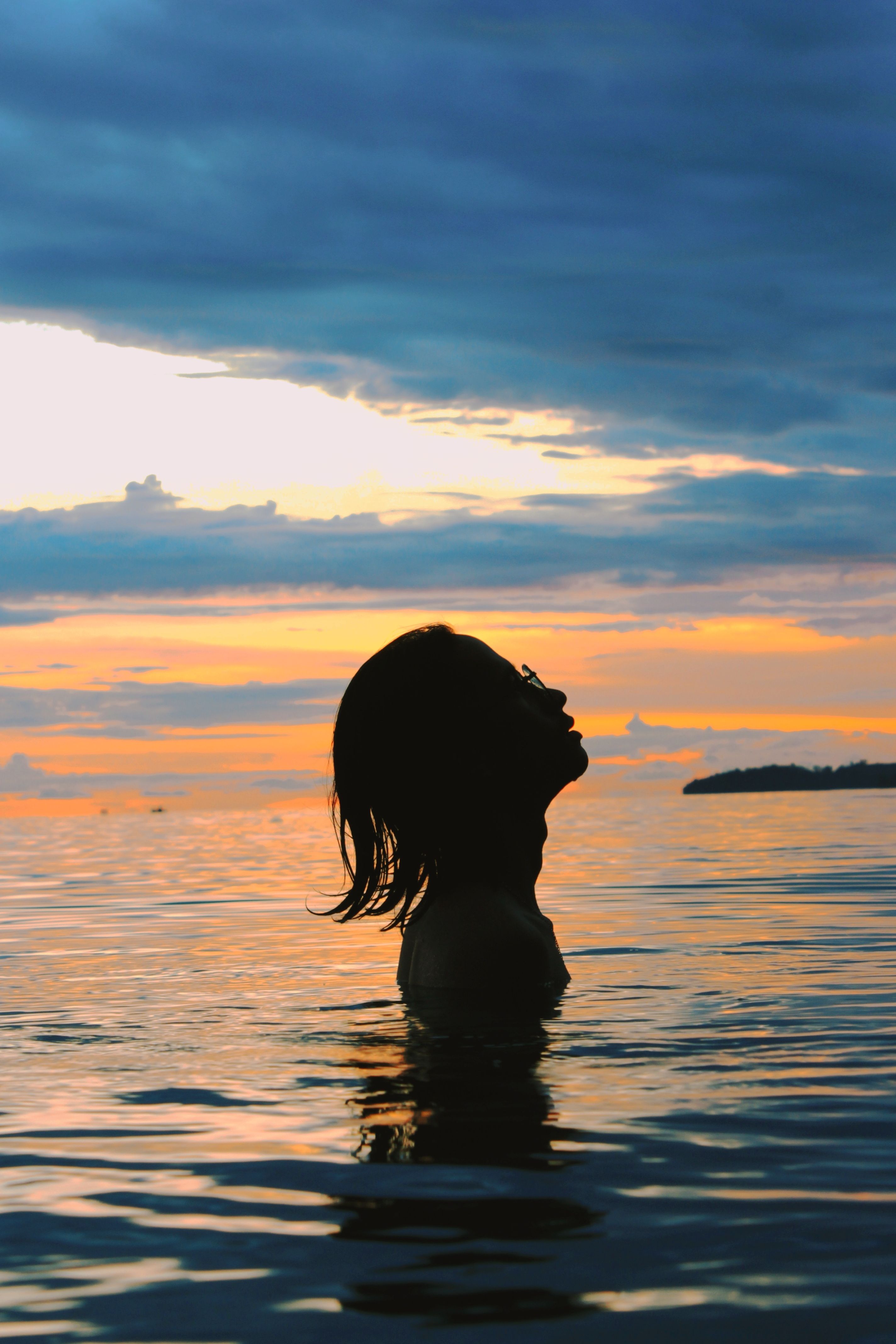 Silhouette of Person on Water During Sunset · Free Stock Photo