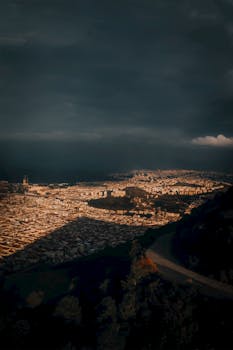 Dramatic aerial view of Izmir cityscape under moody skies at twilight.