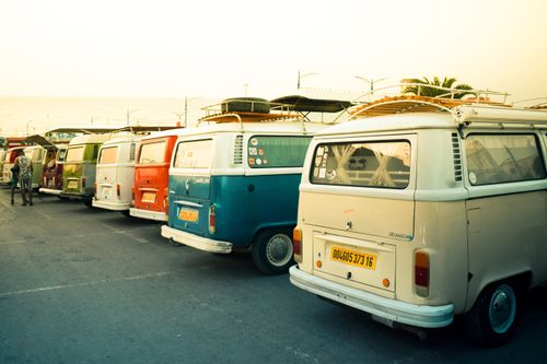 Free A row of vintage Volkswagen vans parked by the coast at sunset in Boumerdès, Algeria. Stock Photo