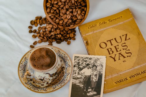 Free Close-Up Shot of a Cup of Coffee beside Coffee Beans Stock Photo