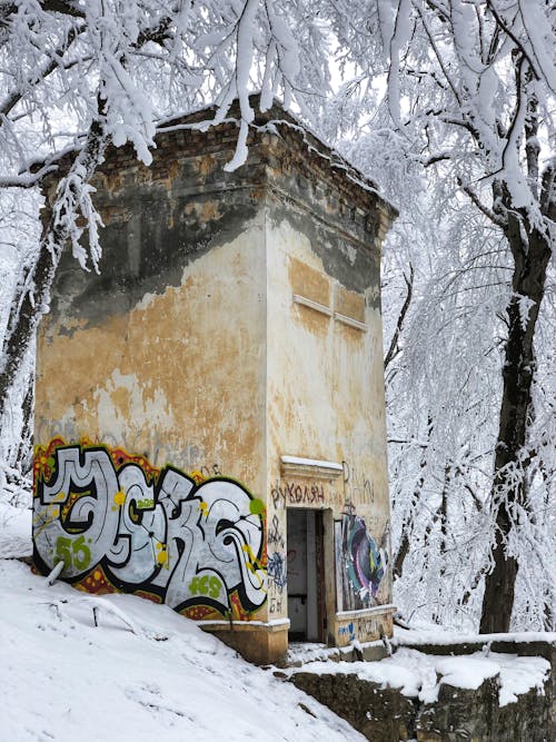 Abandoned Building with Graffiti in Snow 