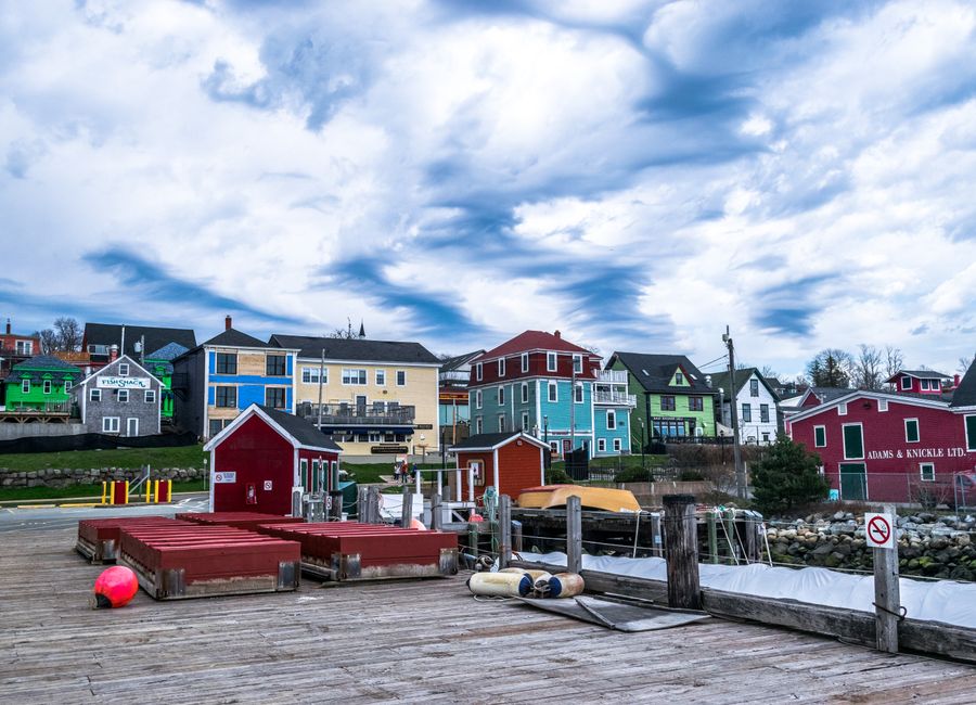 Colorful historic buildings by the harbor under a dramatic sky.