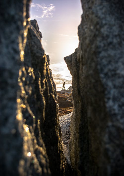 Person Walking on Gray Rock Formation