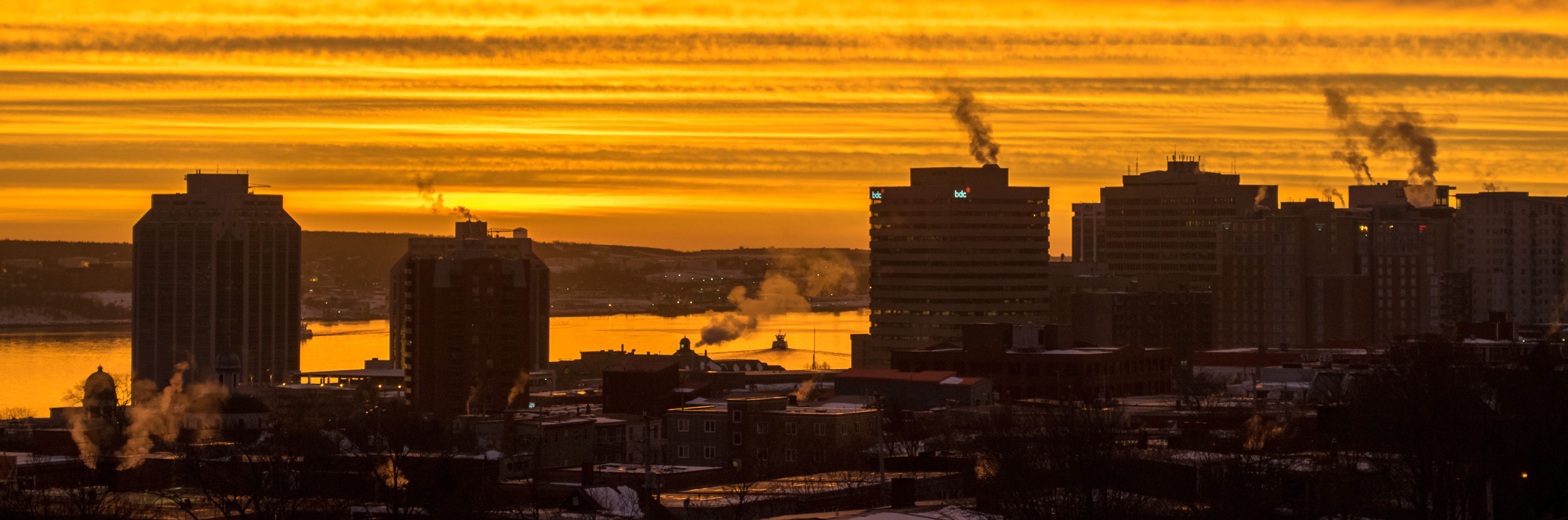 De la fumée s'élève au-dessus d'une ville à l'aube