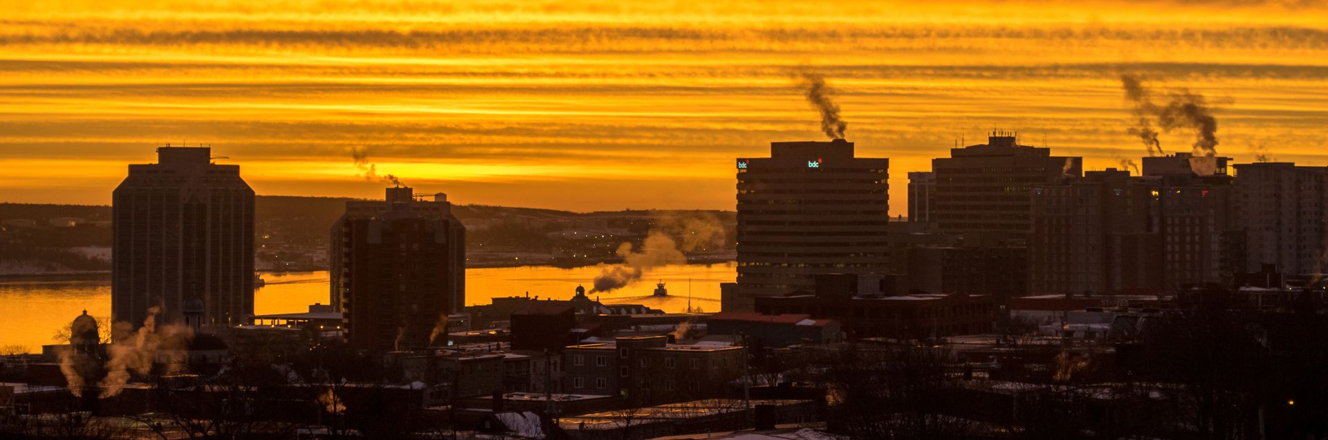 De la fumée s'élève au-dessus d'une ville à l'aube
