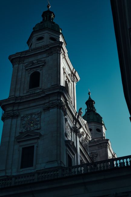 A dramatic view of Salzburg Cathedral's exterior under a clear blue sky.
