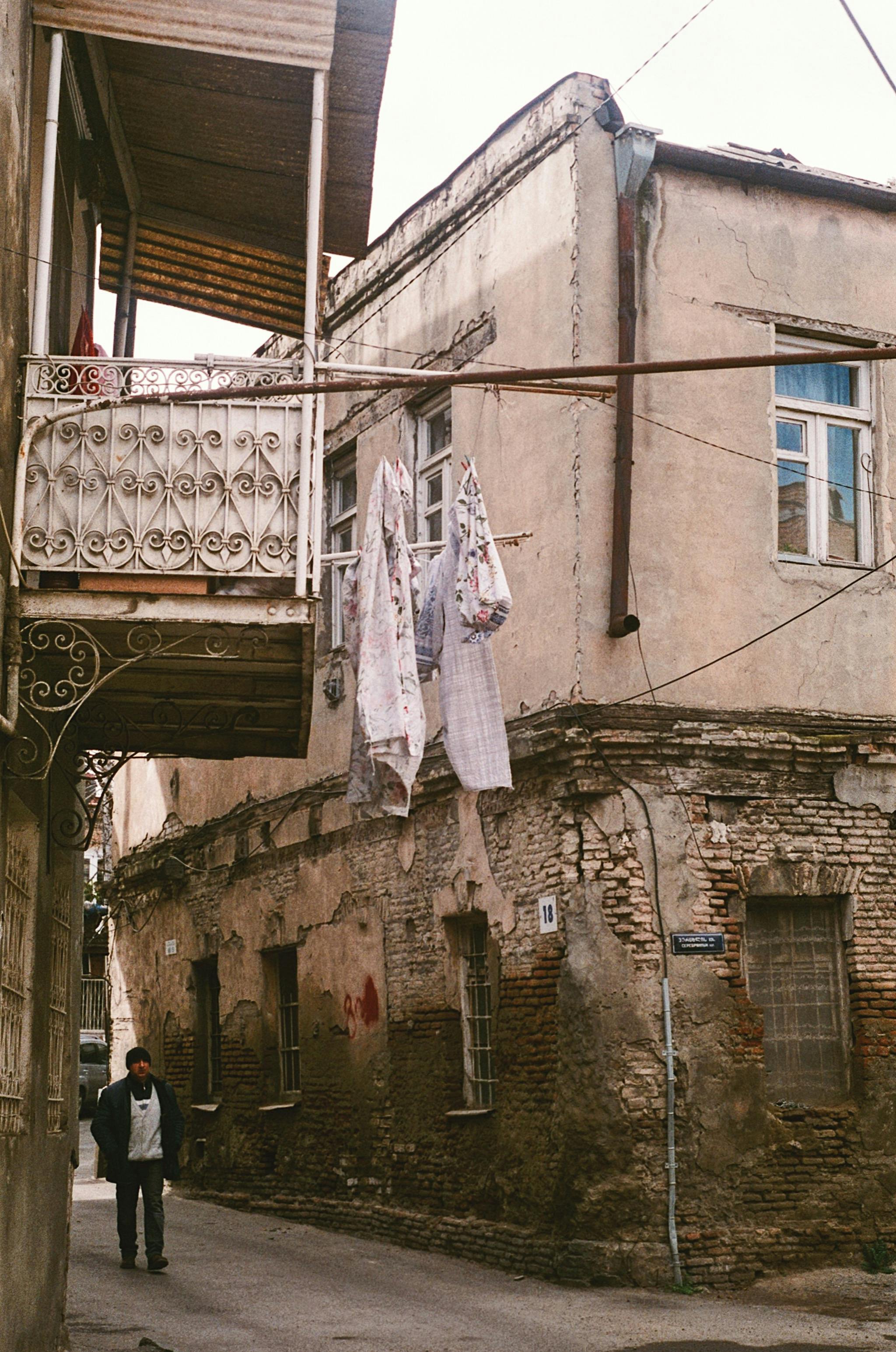 A picturesque glimpse of rustic Tbilisi architecture with clothes hanging on a line.