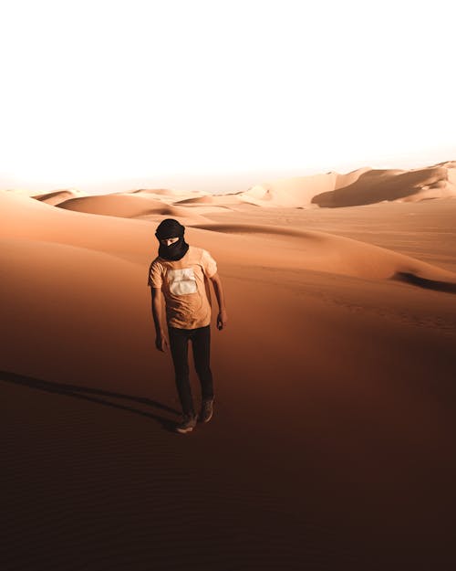 A Person in Black Hijab Walking in the Desert