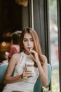 A Pretty Woman in White Dress Sipping a Drink
