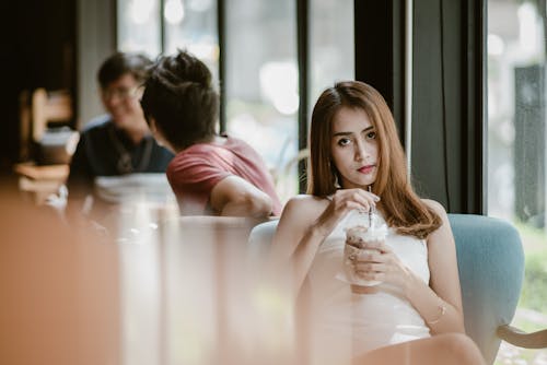 Woman in White Sleeveless Dress Sitting on Chair 