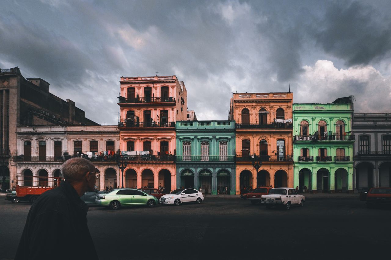 vibrant colonial architecture with gloomy skies and parked cars in urb