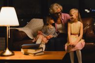 Grandmother bonding with her grandchildren in cozy living room setting.