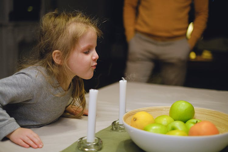 Girl Blowing The White Candle 