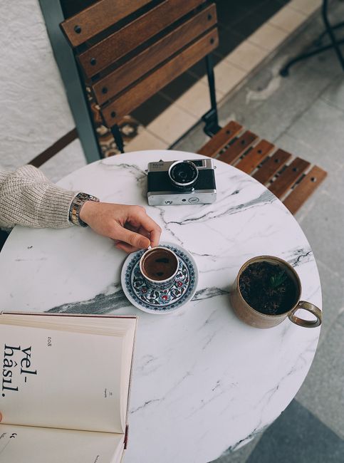 A relaxing coffee break in Istanbul with a classic camera and book on a marble table.