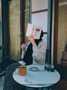 Person in Gray and Black Long Sleeve Shirt Holding White Paper