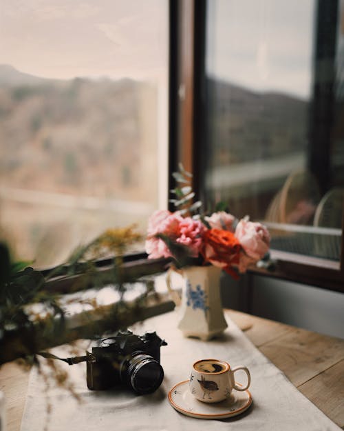 A Camera and a Cup of Coffee on the Table
