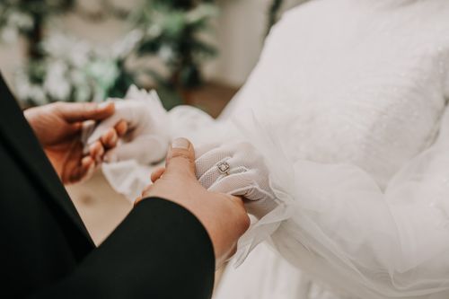 Free Close-up of bride and groom holding hands, highlighting a wedding ring during the ceremony. Stock Photo