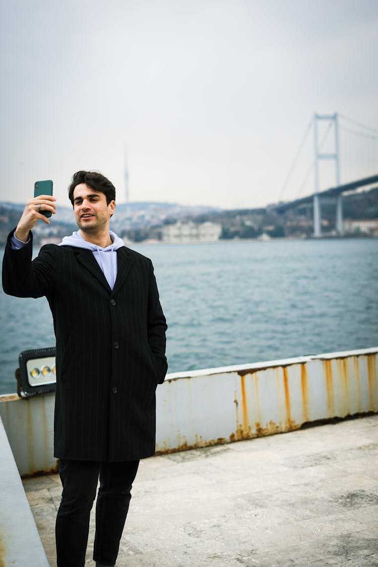 Young Man Taking A Picture On A Pier