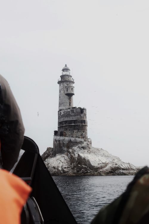 Free The iconic Aniva Lighthouse stands isolated on a rocky outcrop in the sea near Sakhalin Island, Russia. Stock Photo