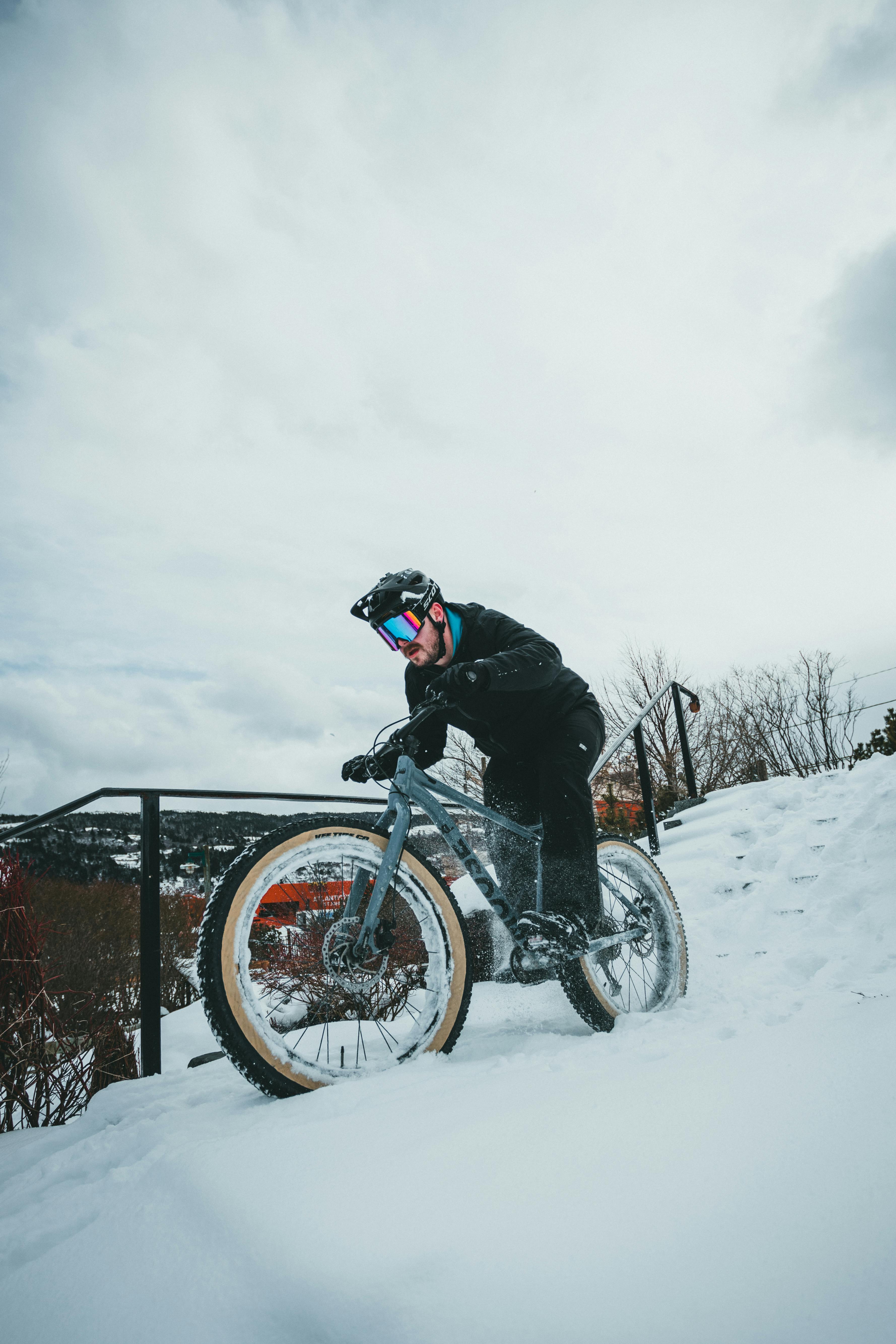 Man in Black Jacket Riding on White and Black Mountain Bike on