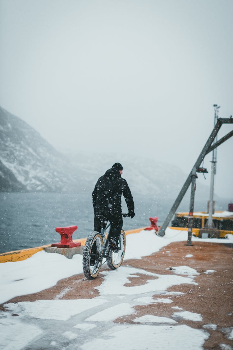 Man Cycling In Snow