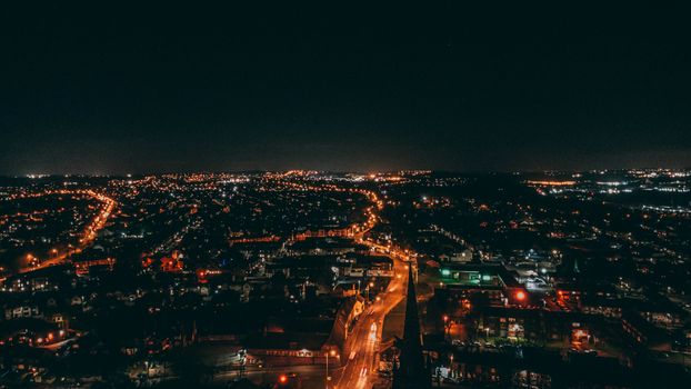 Explore a stunning aerial view of a city illuminated by vibrant lights under the night sky.