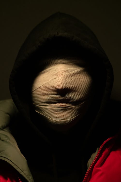 Portrait of Person in Hoodie with Face Covered in Bandages