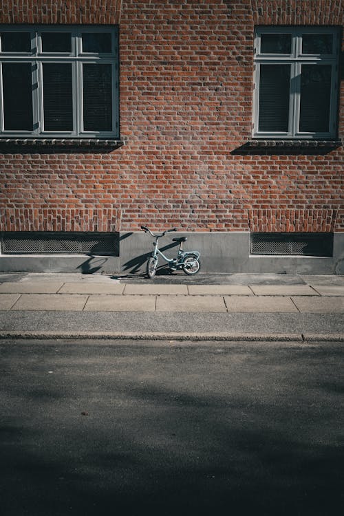 Bicycle Parked Beside Brick Walls