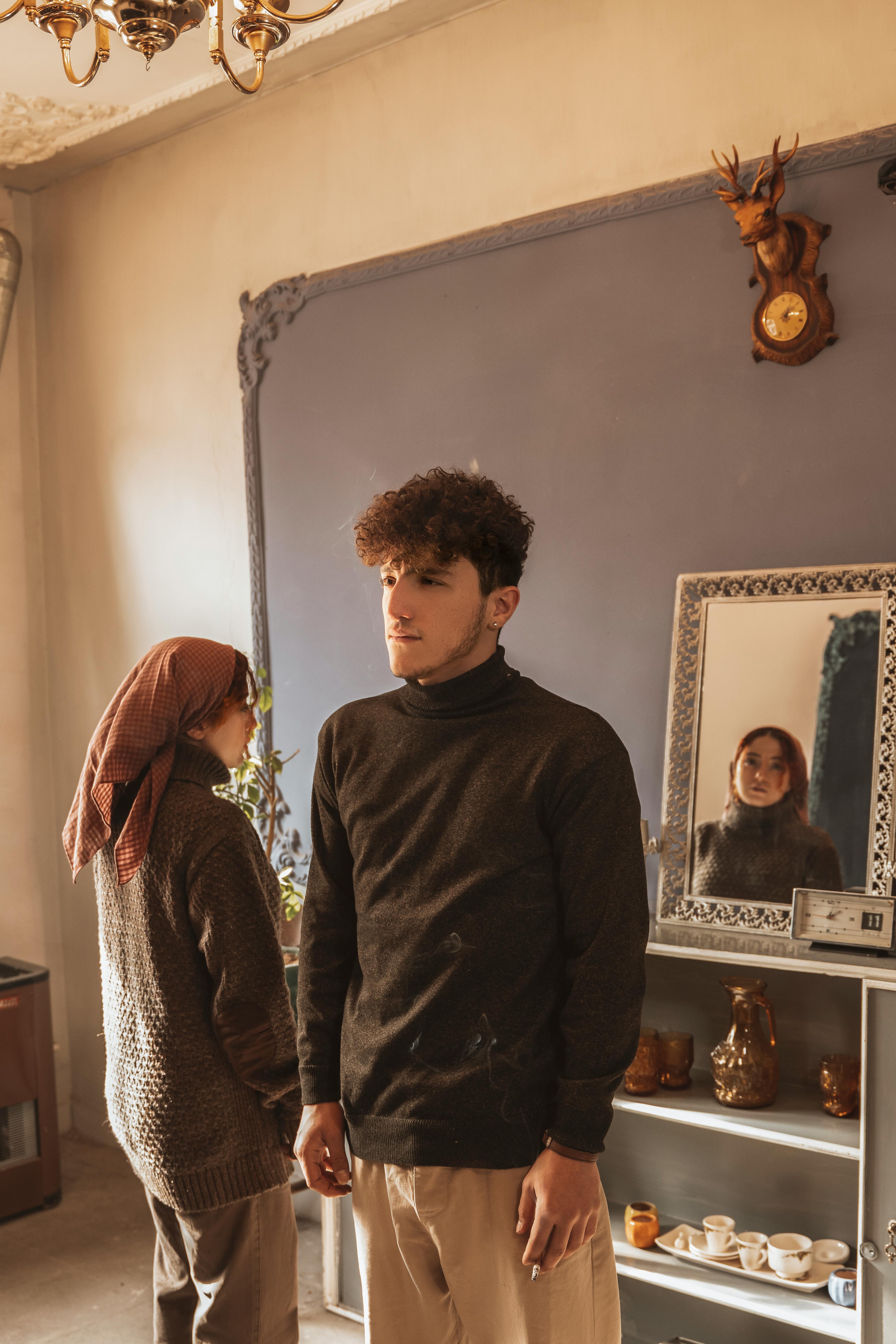 young man and woman standing inside in opposite directions