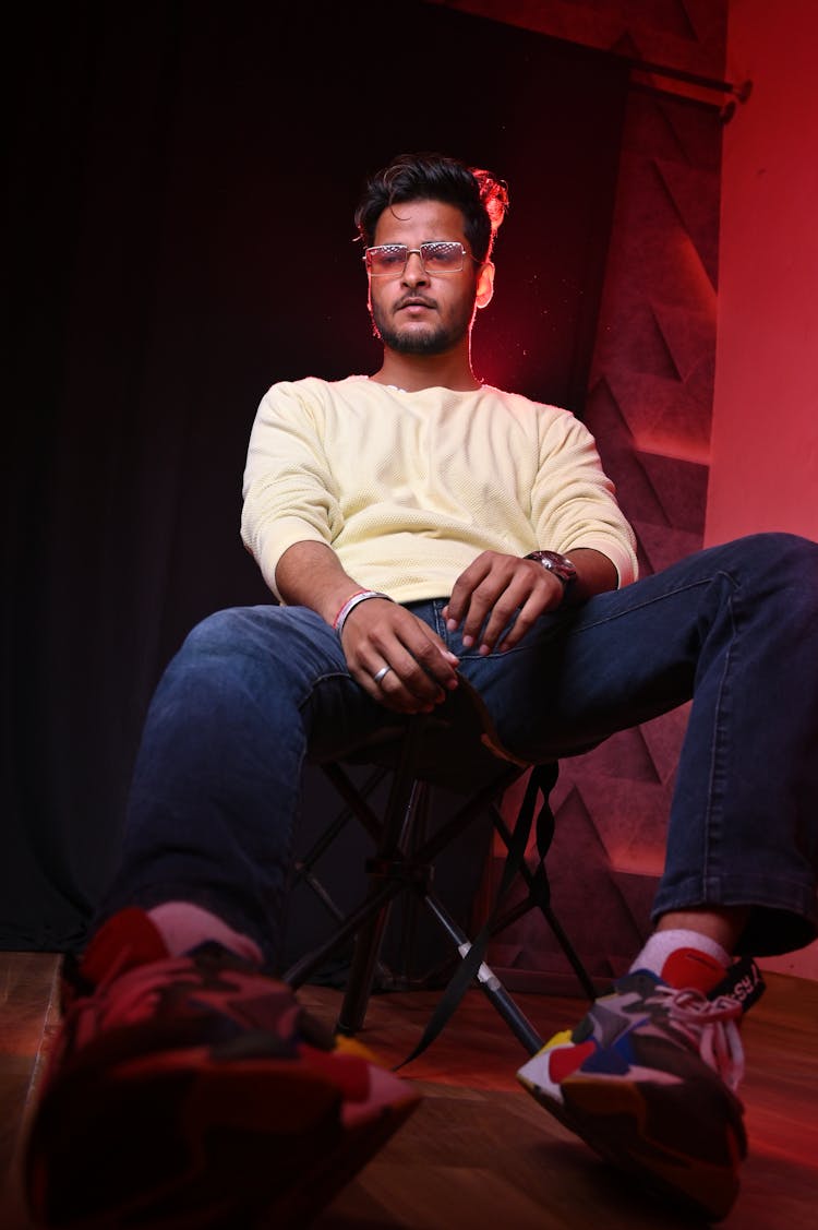 Man In Yellow Sweatshirt Sitting On A Chair