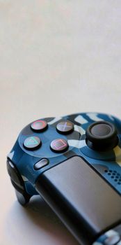 Close-up of a blue camouflage game controller with control buttons.