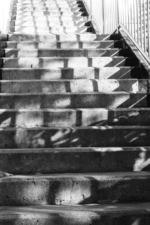 Free Artistic black and white staircase with abstract shadows on concrete steps, creating a dramatic and moody atmosphere. Stock Photo