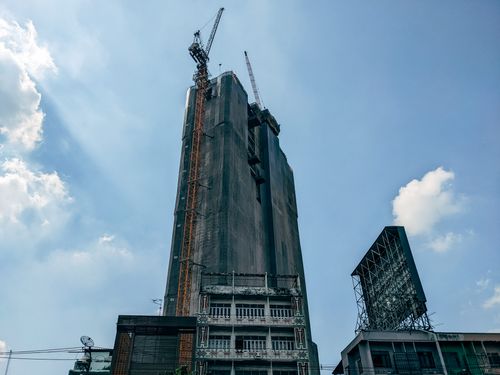Free A towering skyscraper in an urban setting under construction, capturing city life and architectural progress. Stock Photo