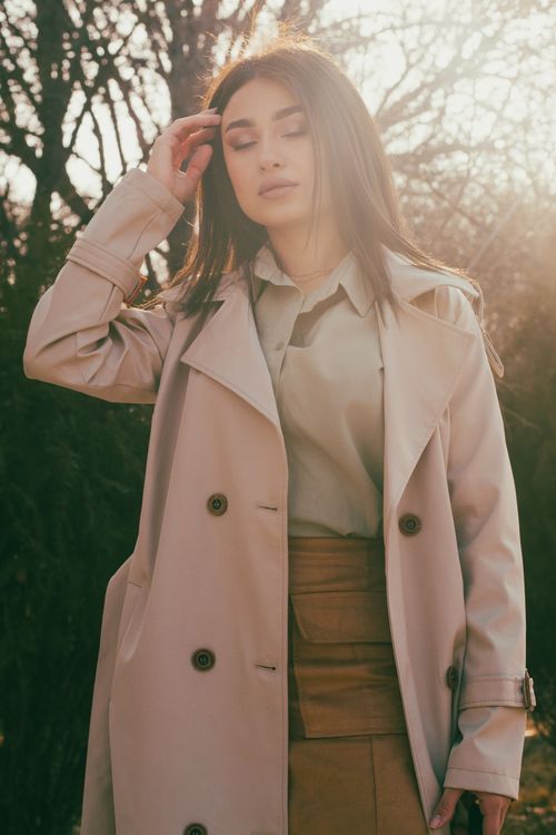 Brown trench coat with black turtleneck and jeans