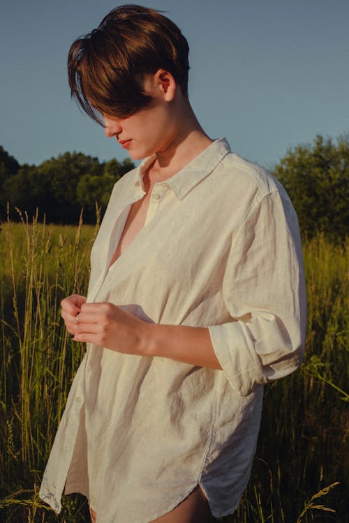 Woman in White Long Sleeve Shirt Standing in the Field