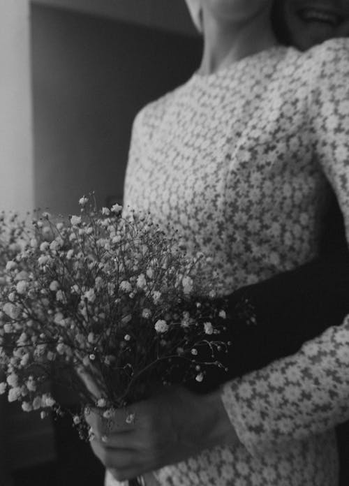 Grayscale Photography of Woman in Lace Dress Holding Flowers