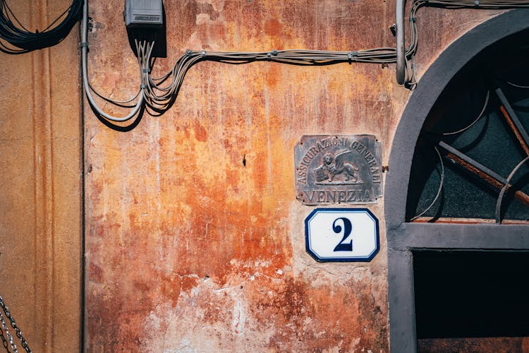 Number Sign On A Wall Near An Arched Window