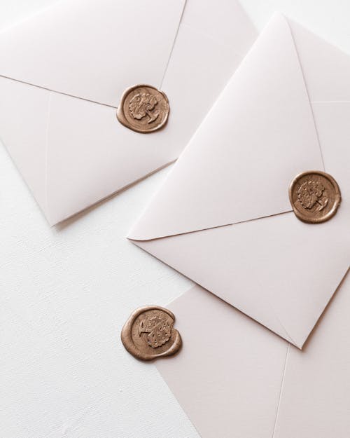 Three White Envelopes Scattered on White Table