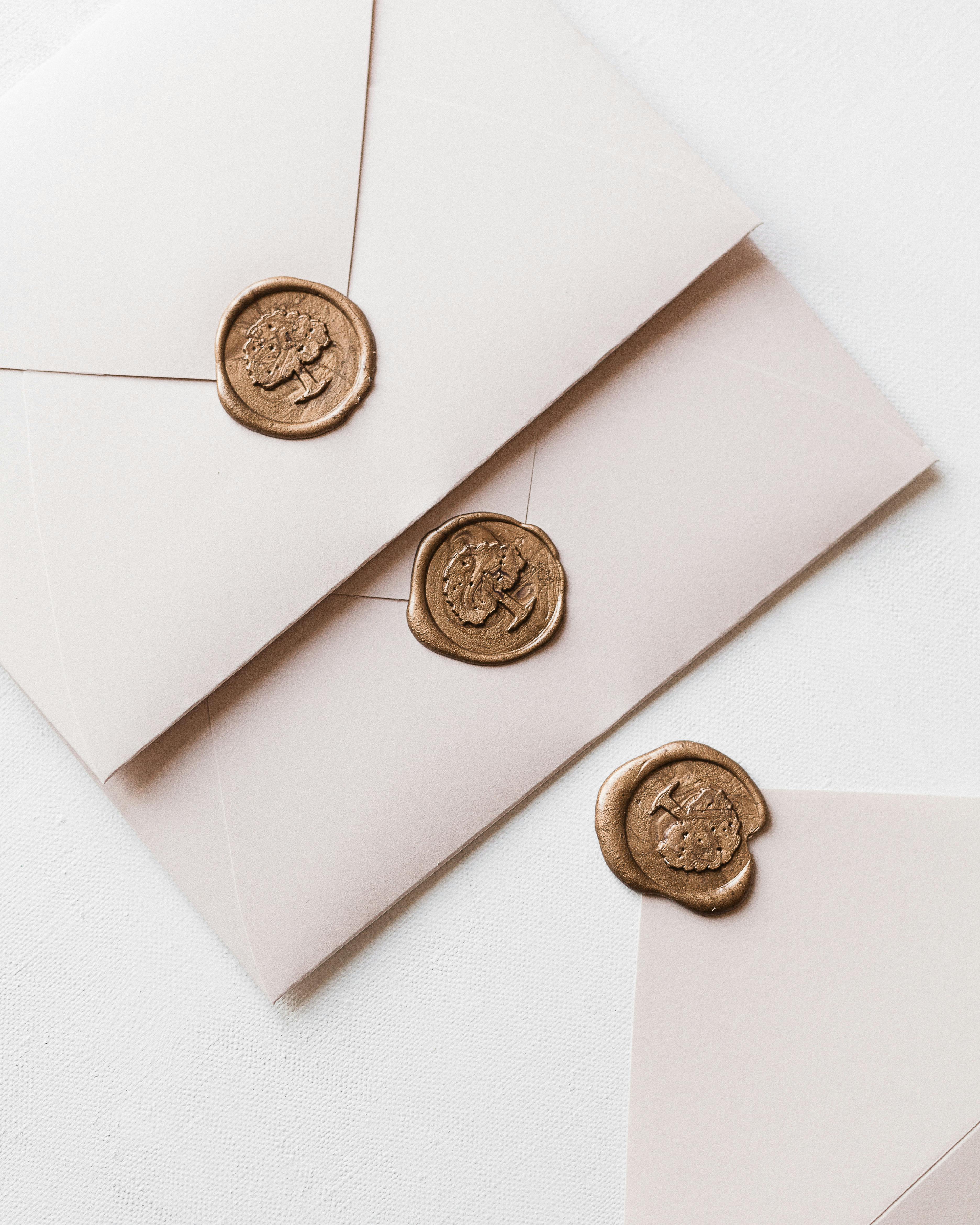 three white envelopes with wax seal arranged in row