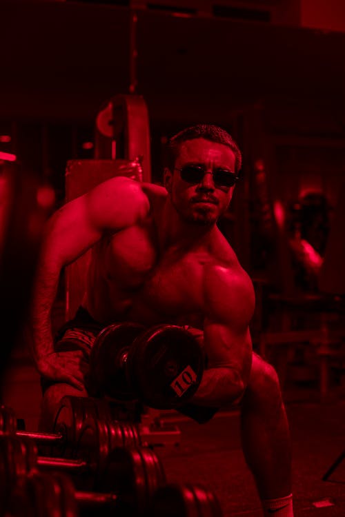 A Muscular Man Lifting Weights in the Gym