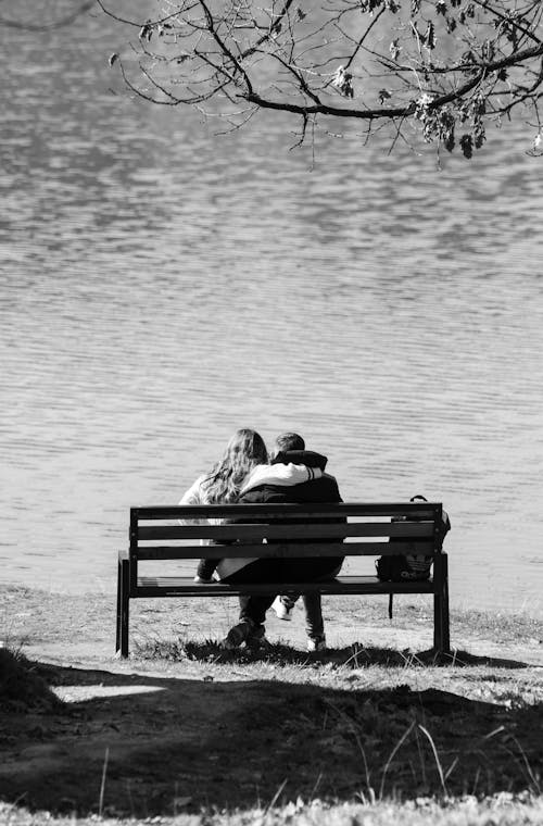 Free Grayscale Photo of a Couple Sitting on a Bench Stock Photo