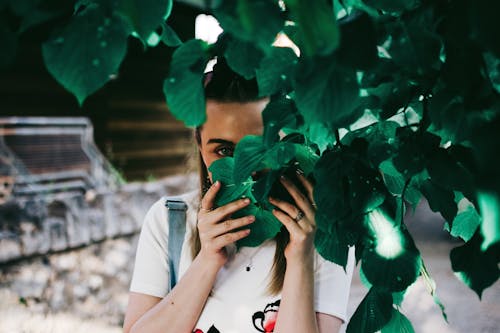 Woman Holding Leaves Covering Her Face
