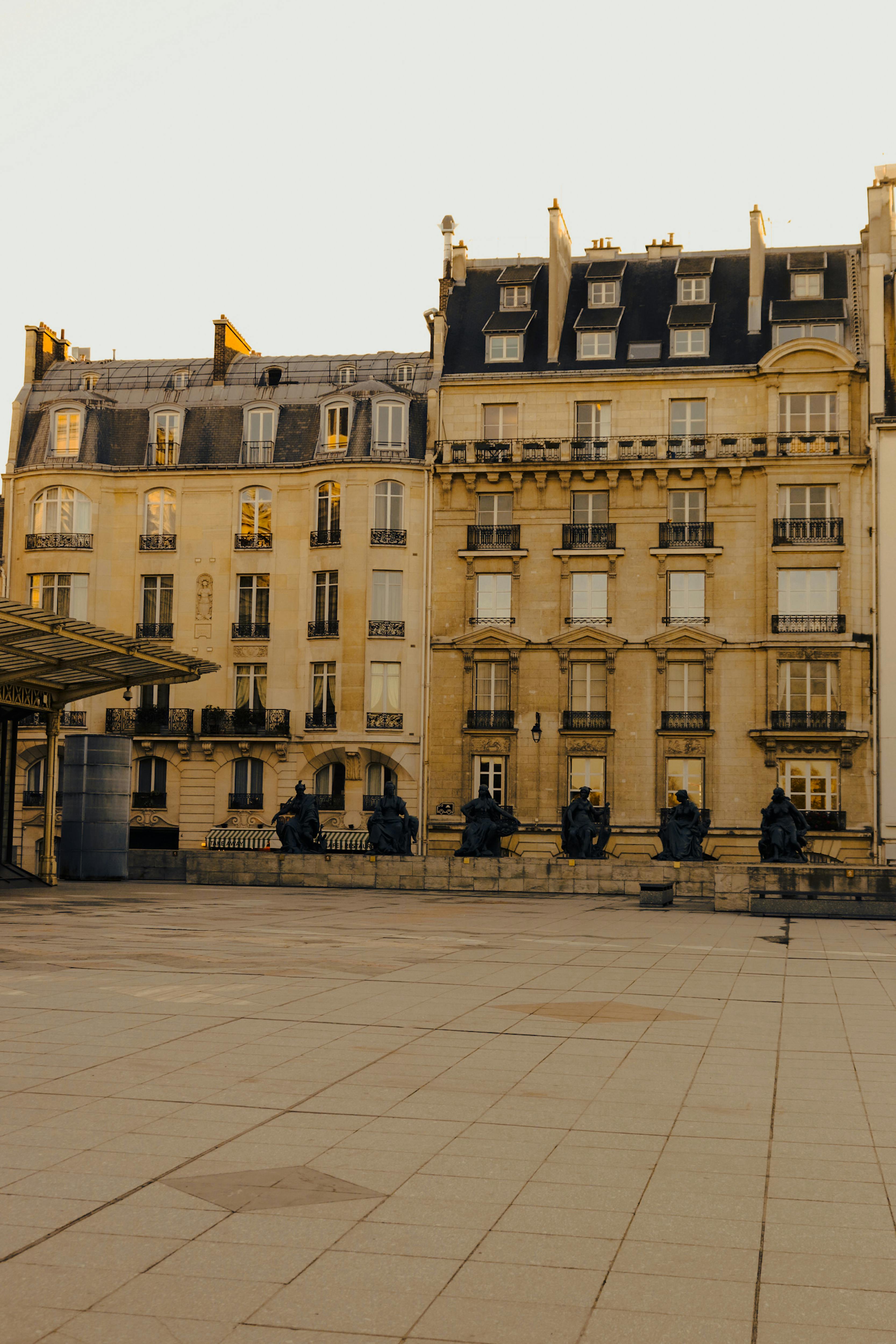 Elegant Parisian building facade in warm sunset light, featuring classic architecture and urban tranquility.