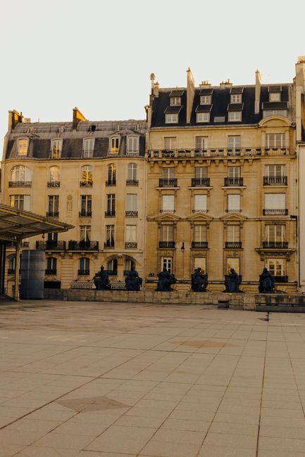 Elegant Parisian building facade in warm sunset light, featuring classic architecture and urban tranquility.