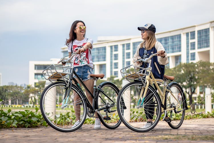 Women Walking With Their Bikes