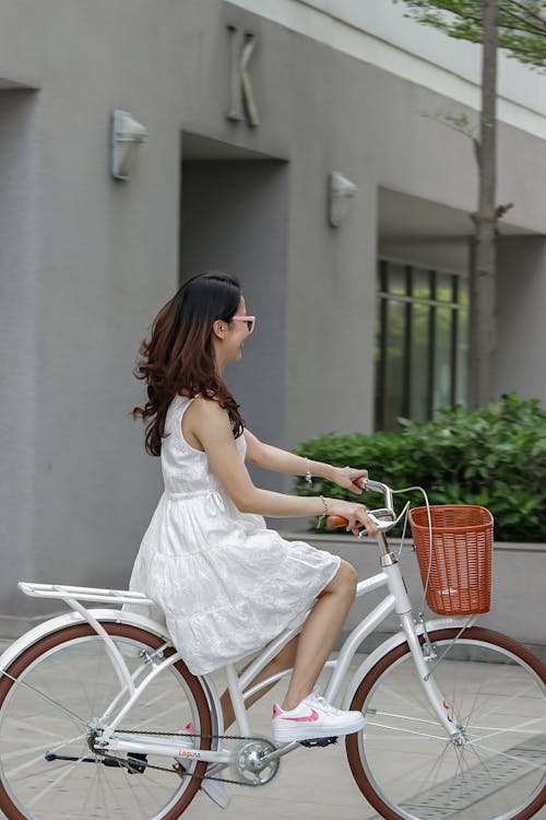 Woman in White Dress Riding a Bicycle