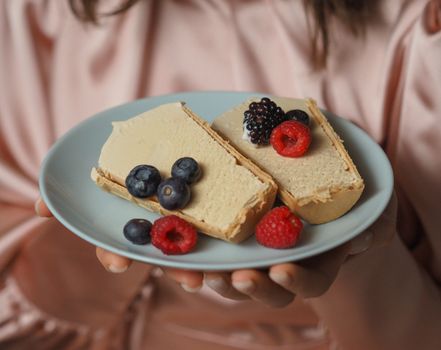 Close-up of a creamy dessert topped with fresh berries on a plate, perfect for sweet indulgence.